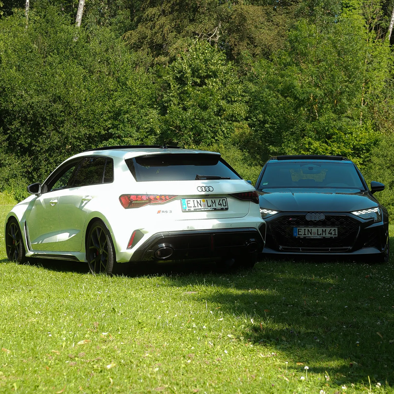 Weißer RS3 Sportback von hinten, dunkelgrauer Sportback von vorn