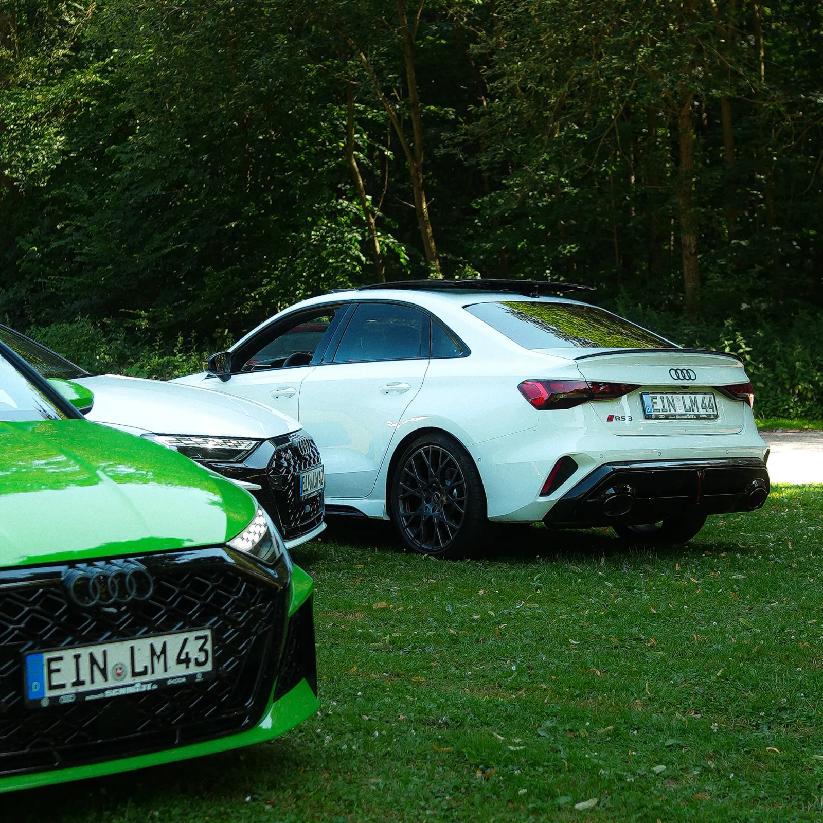 Weiße RS3 Limousine, daneben die grüne Limousine