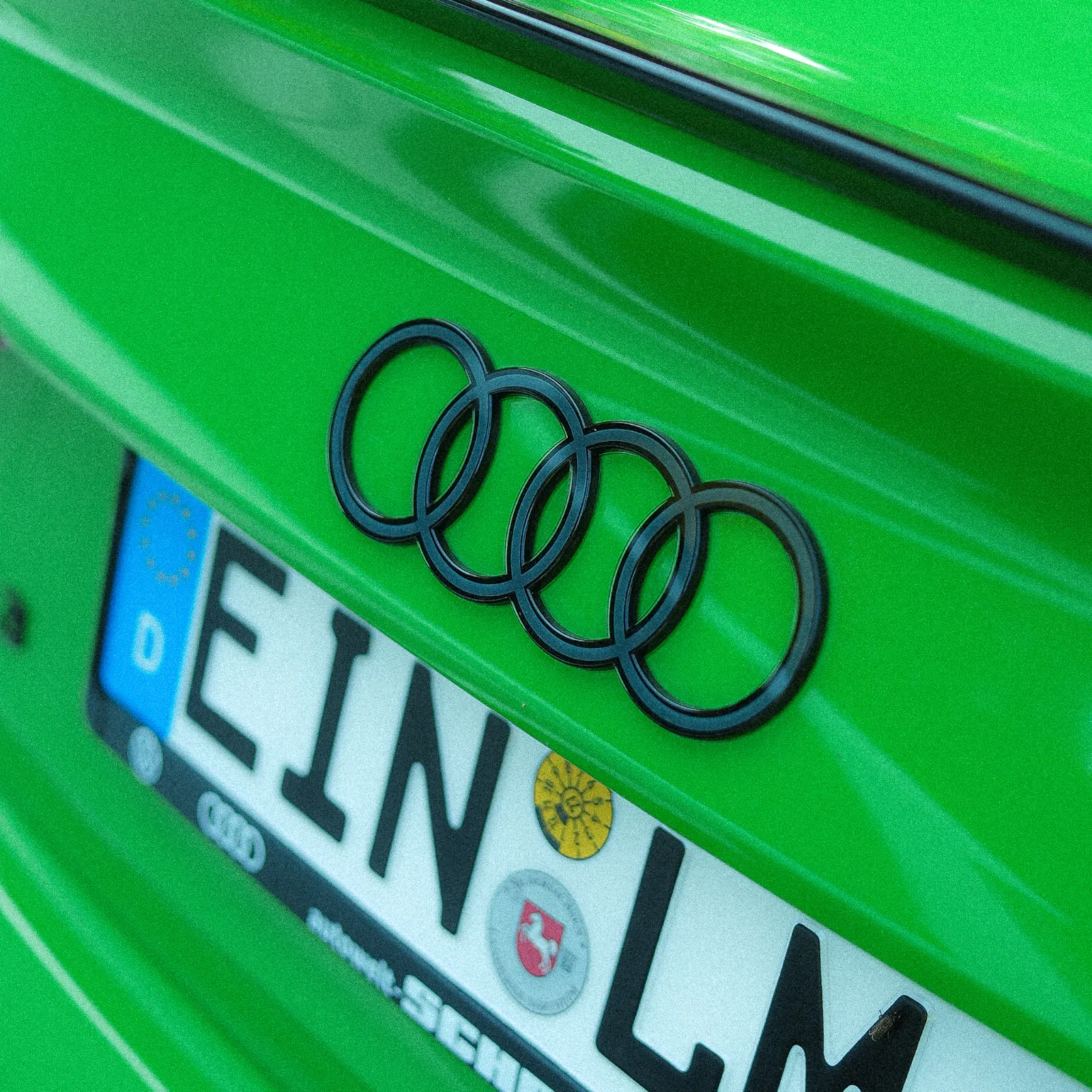 Schwarze Audi-Ringe am grünen Heck